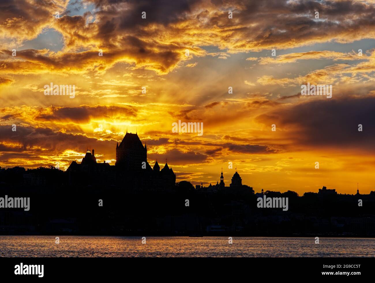The Quebec City skyline silhouetted against a fiery sunset, as seen from Lévis, Canada Stock Photo