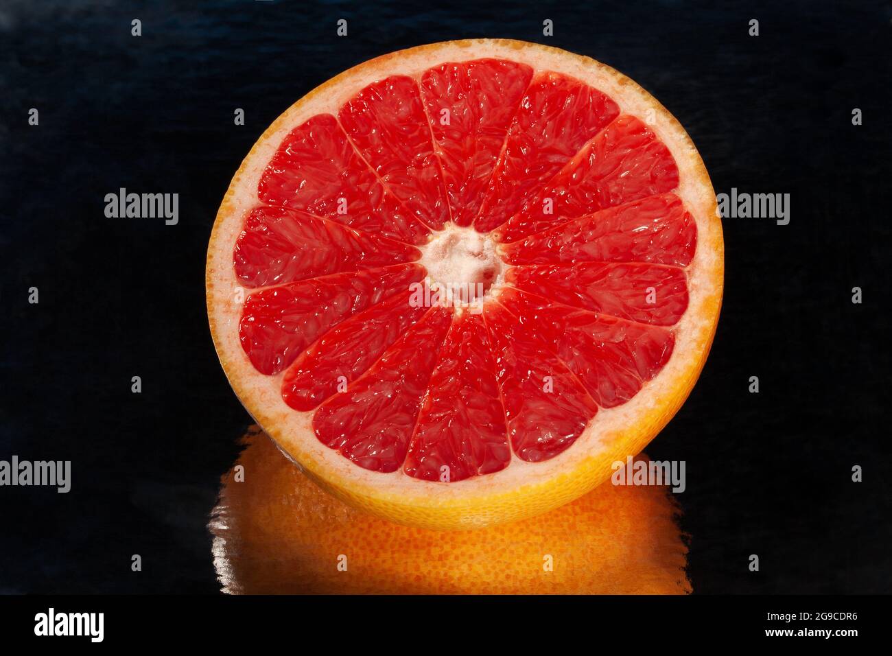 sliced mirrored grapefruit on black background Stock Photo