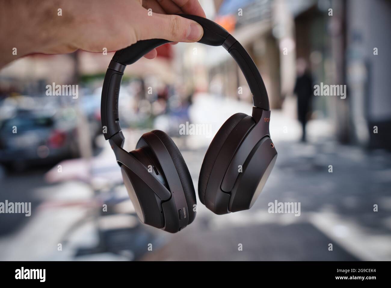 MUNICH, GERMANY - Jul 16, 2021: A selective focus shot of a hand holding a  pair of Sony wh-1000xm3 headphones outdoors Stock Photo - Alamy