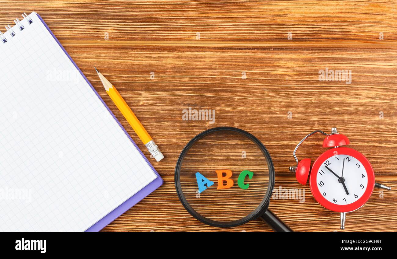Notepad with school supplies on a wooden desk. Stock Photo