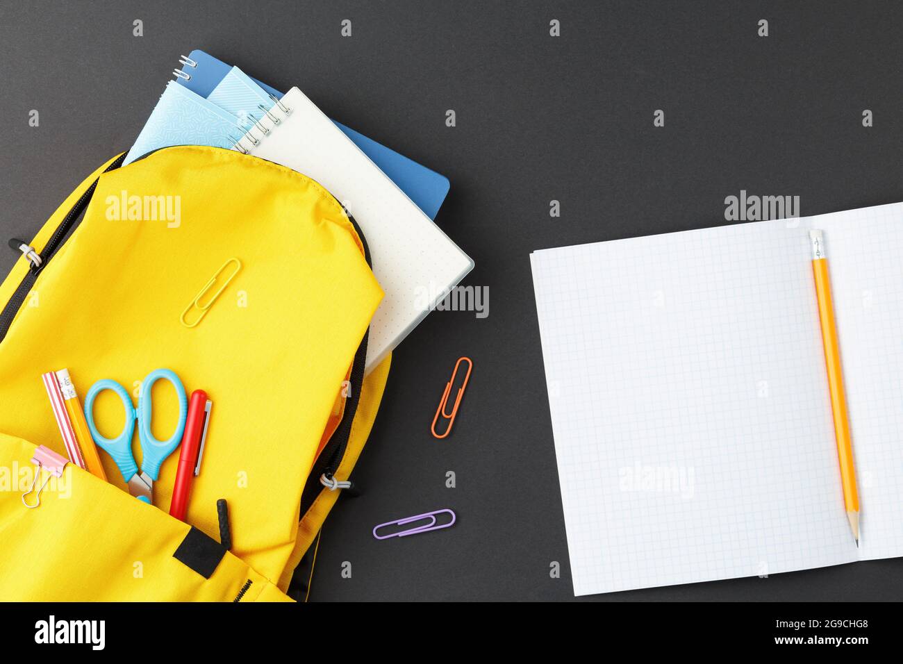 School supplies in a yellow backpack. Stock Photo