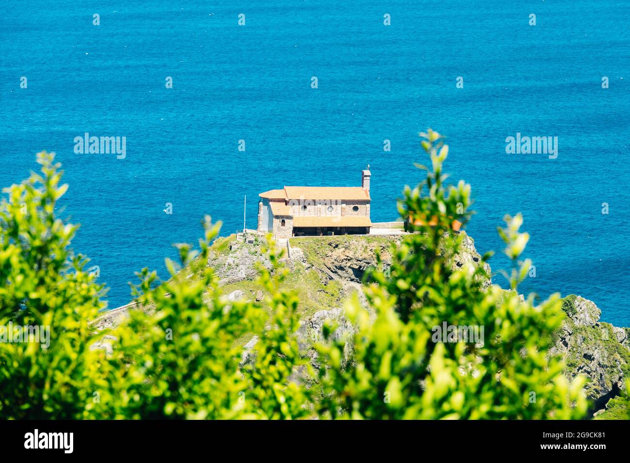 Photograph of the sunny landscape with the hermitage San Juan de Gastegulatxe Sanctuary in Bermeo Bilbao on the Cantabrian Sea of Spain on a summer da Stock Photo