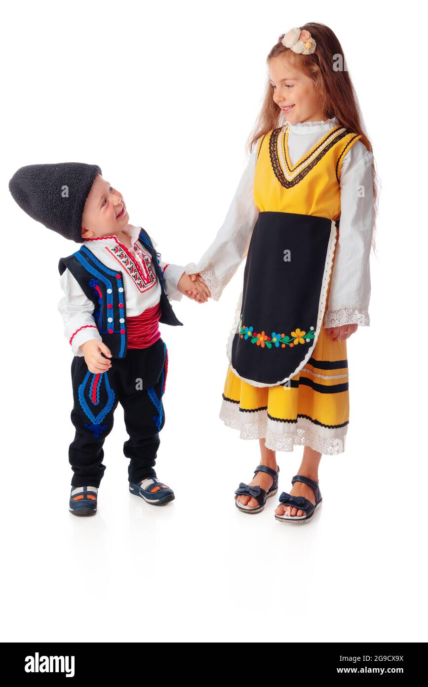 Boy and girl in traditional Bulgarian folklore costumes. Happy kids, brother and sister posing. Stock Photo
