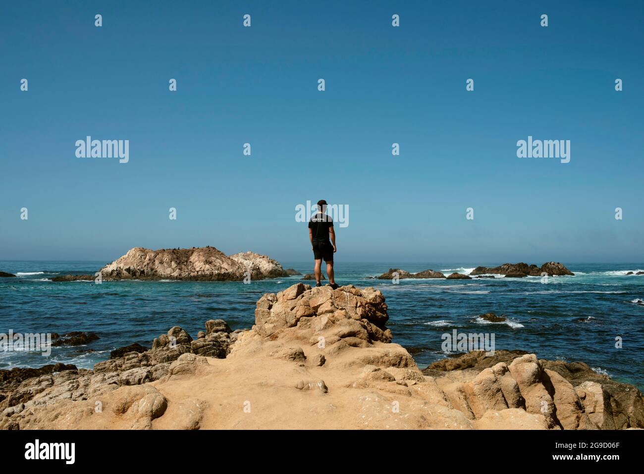 Rear view of man looking at ocean views. Bird Rock, 17 Mile Drive, Rocky Coastline, Monterey Peninsula, California, USA. Sep 2019 Stock Photo