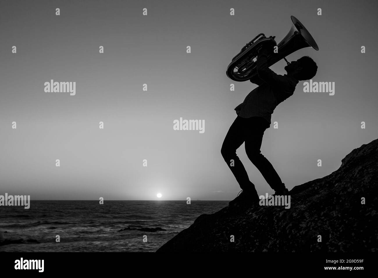 Silhouette of a musician with a trumpet on the seashore. Black and white photo. Stock Photo