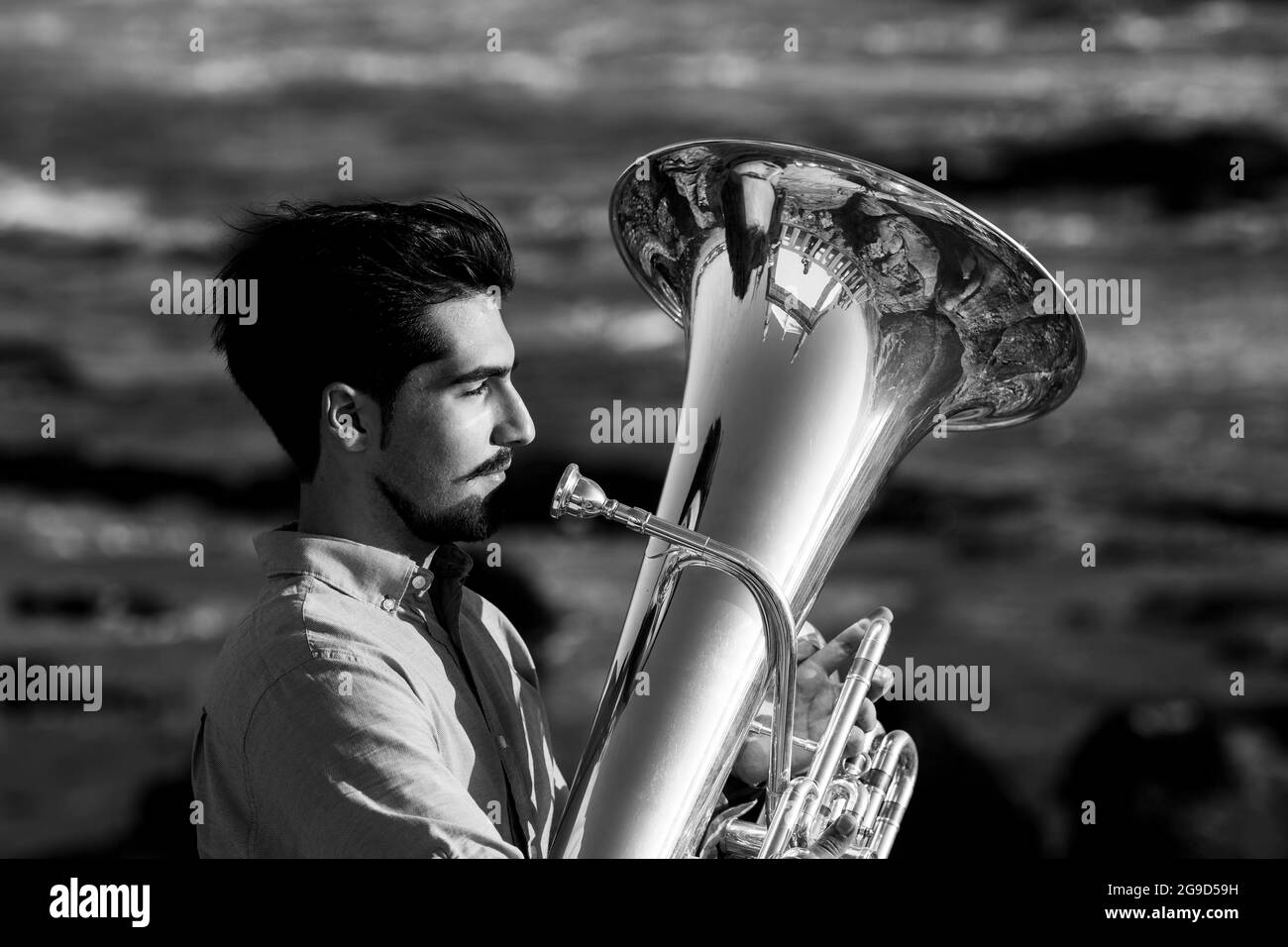 Portrait of musician with a trumpet on the seashore. Black and white photo. Stock Photo