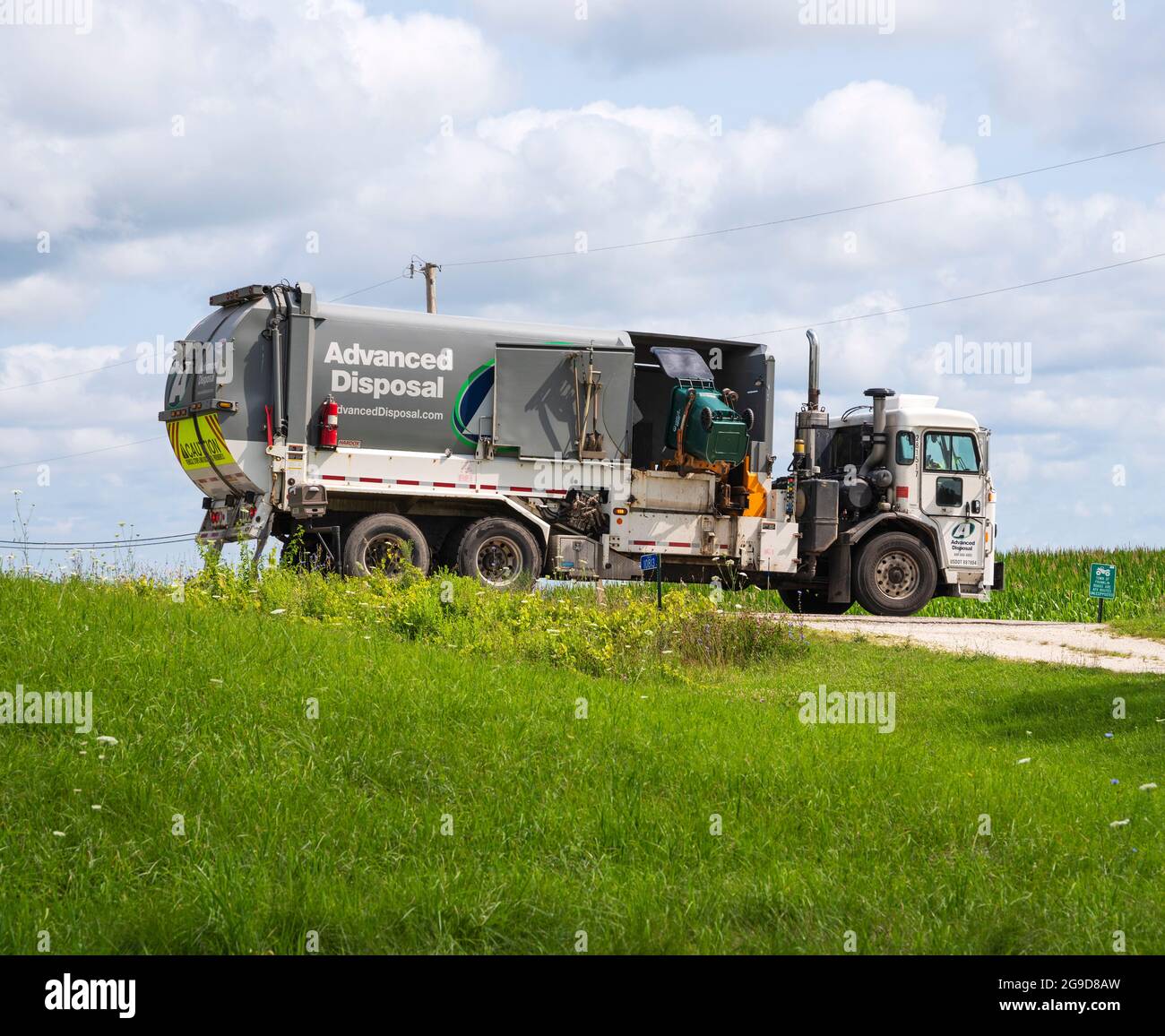 Advanced Disposal garbage truck or trash collection lorry  with automatic loader emptying refuse disposal container. Stock Photo