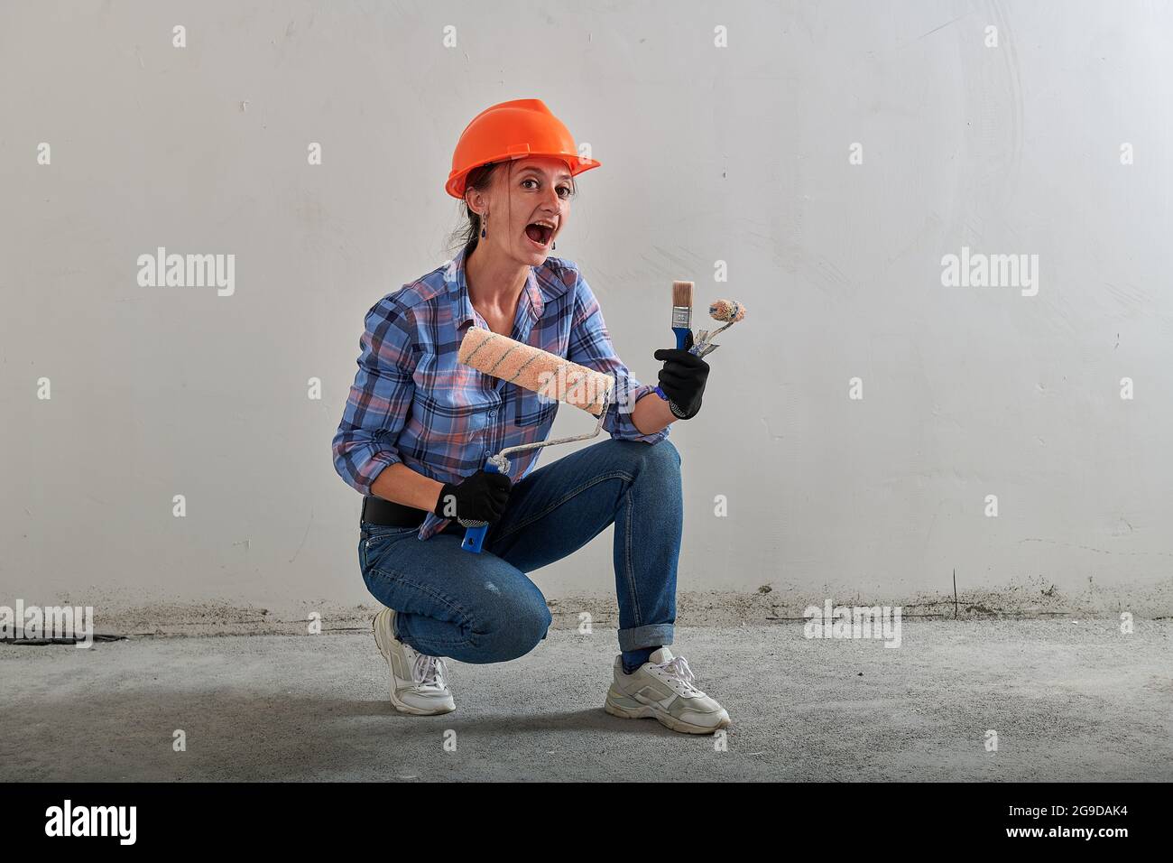 paint roller in the hands of a funny foreman with brushes Stock Photo ...