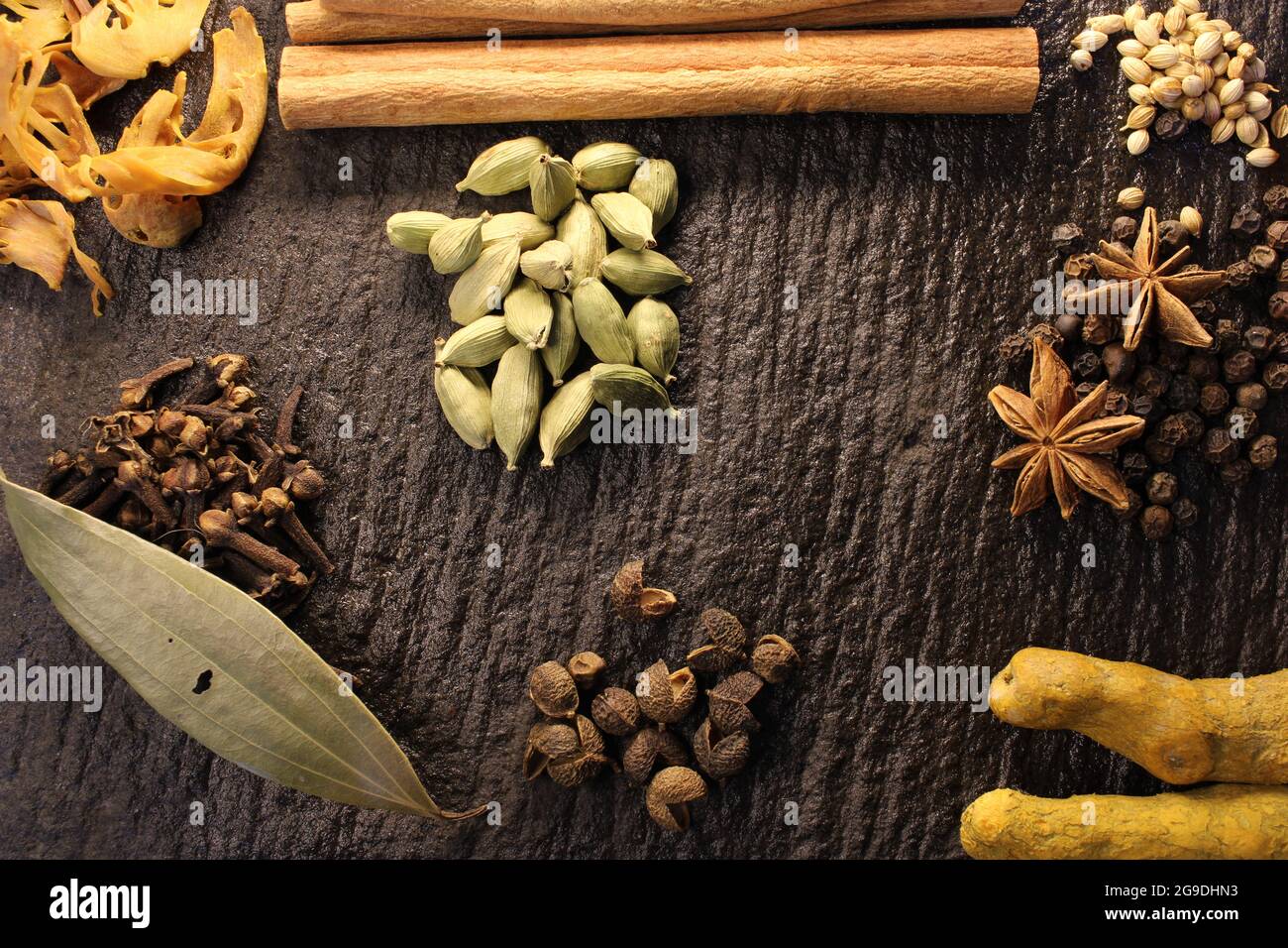 Most common and flavourful Indian Spices. Spices used in Indian food. Spices in traditional masala grinding stone Stock Photo