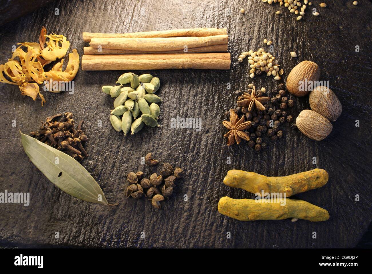 Most common and flavourful Indian Spices. Spices used in Indian food. Spices in traditional masala grinding stone Stock Photo