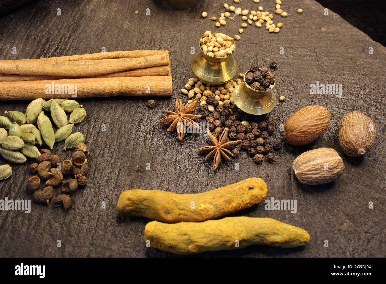 Most common and flavourful Indian Spices. Spices used in Indian food. Spices in traditional masala grinding stone Stock Photo