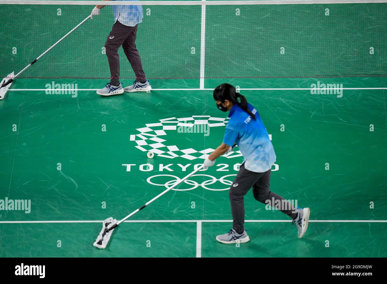 TOKYO, JAPAN - JULY 26: Volunteers of Tokyo 2020 are cleaning the floor  competing on Mixed Doubles Group Play Stage - Group A during the Tokyo 2020  Olympic Games at the Musashino