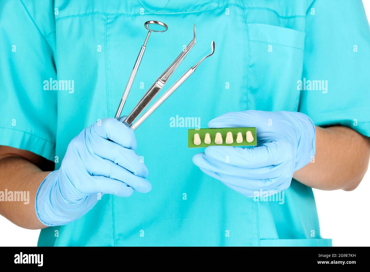 dentists hands in blue medical gloves with dental tools and denture