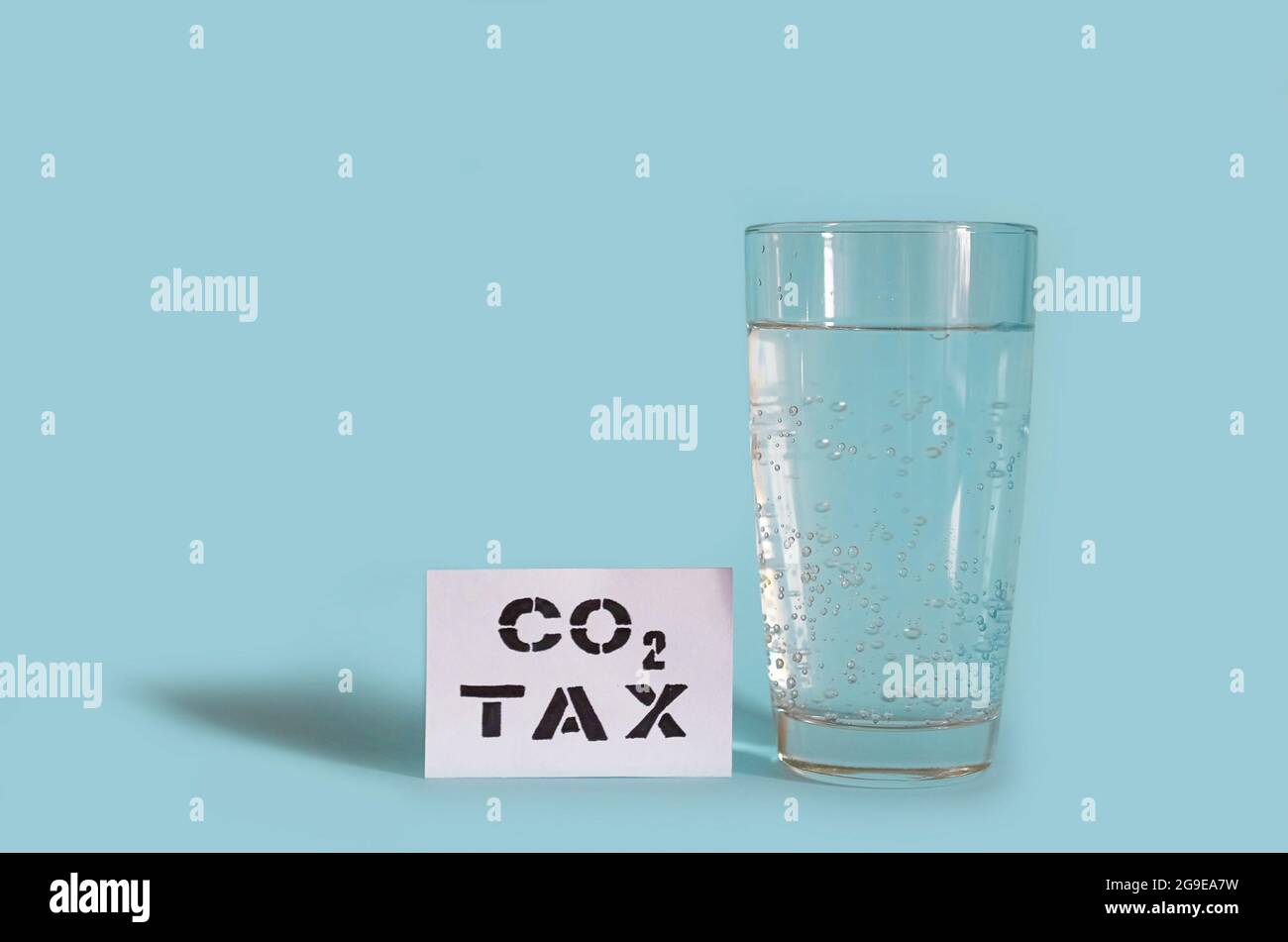 A glass of sparkling water and a card with the inscription Carbon tax  Stock Photo