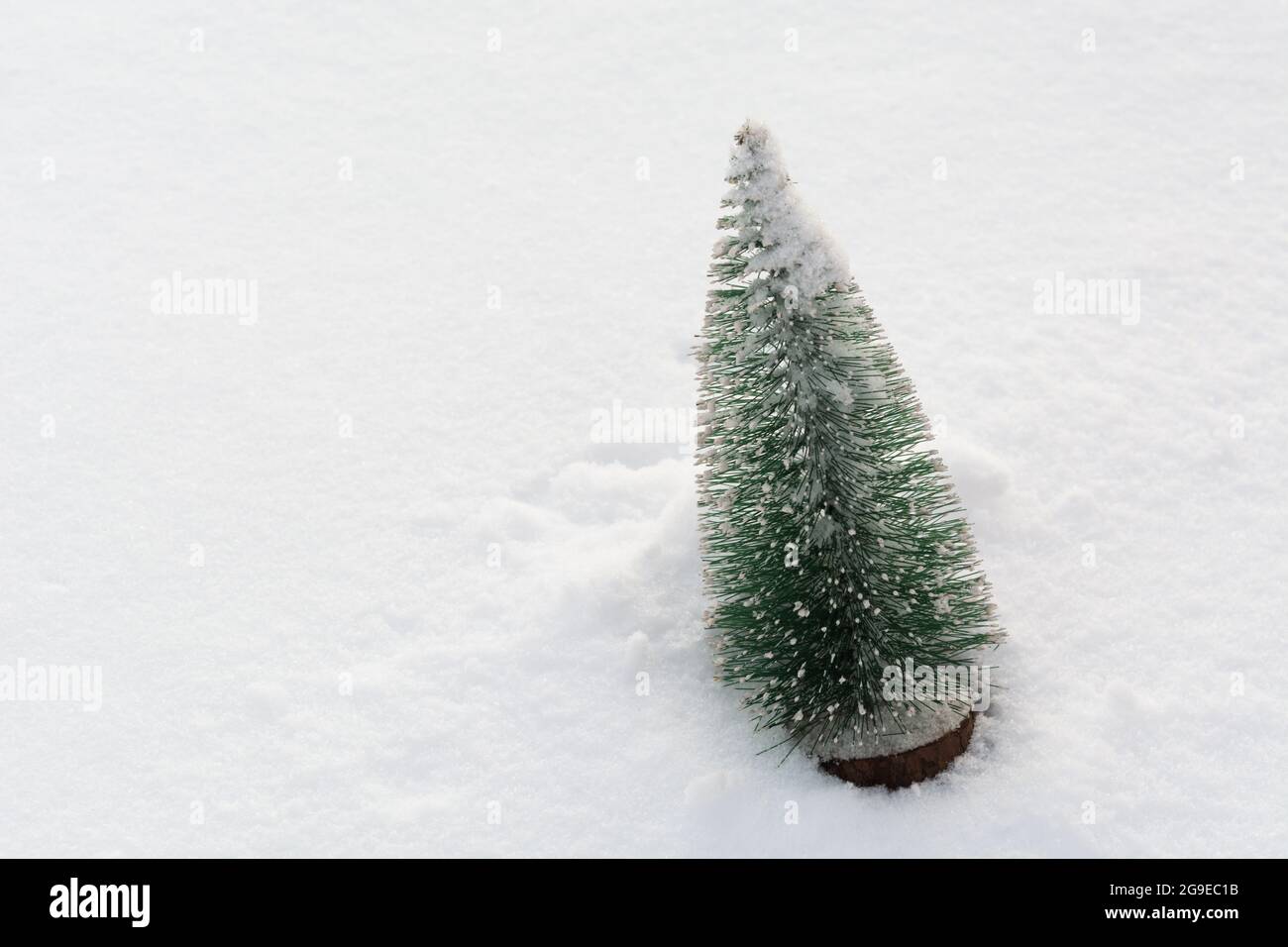 Plastic christmas tree on real snow with copy space. Winter holiday background Stock Photo