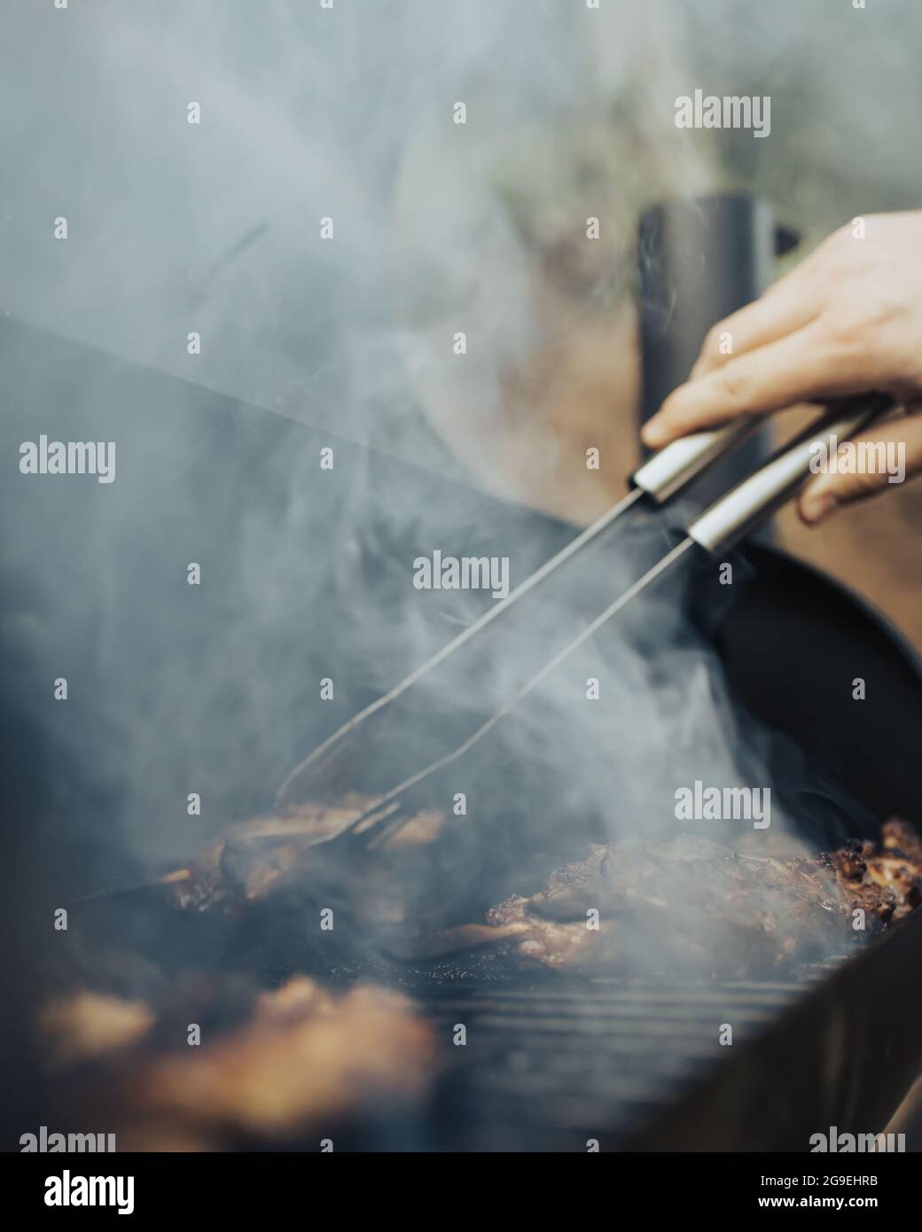 Vertical shot of barbecue with smoke on the grill Stock Photo - Alamy
