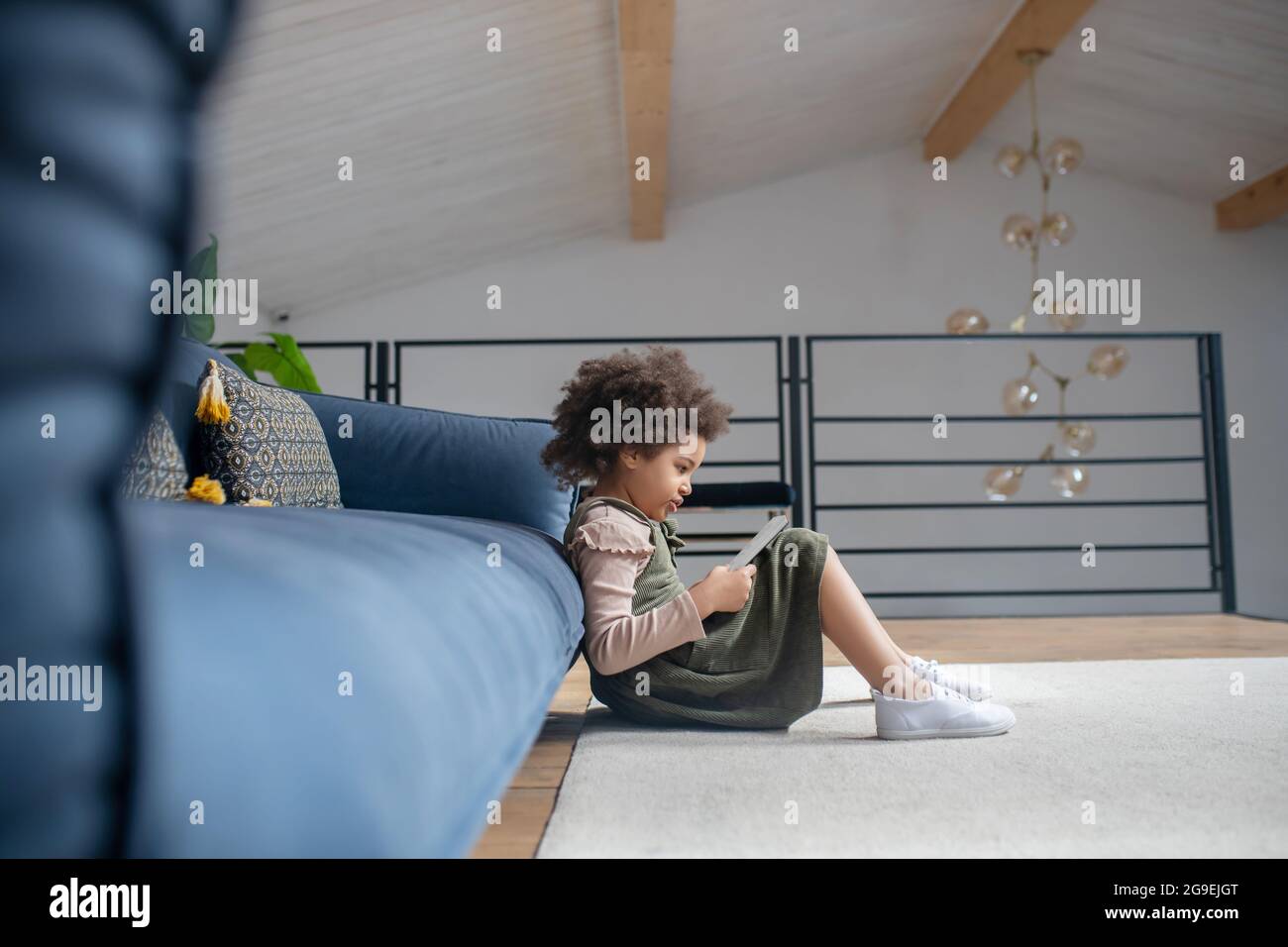 Little girl reading sitting on floor at home Stock Photo - Alamy