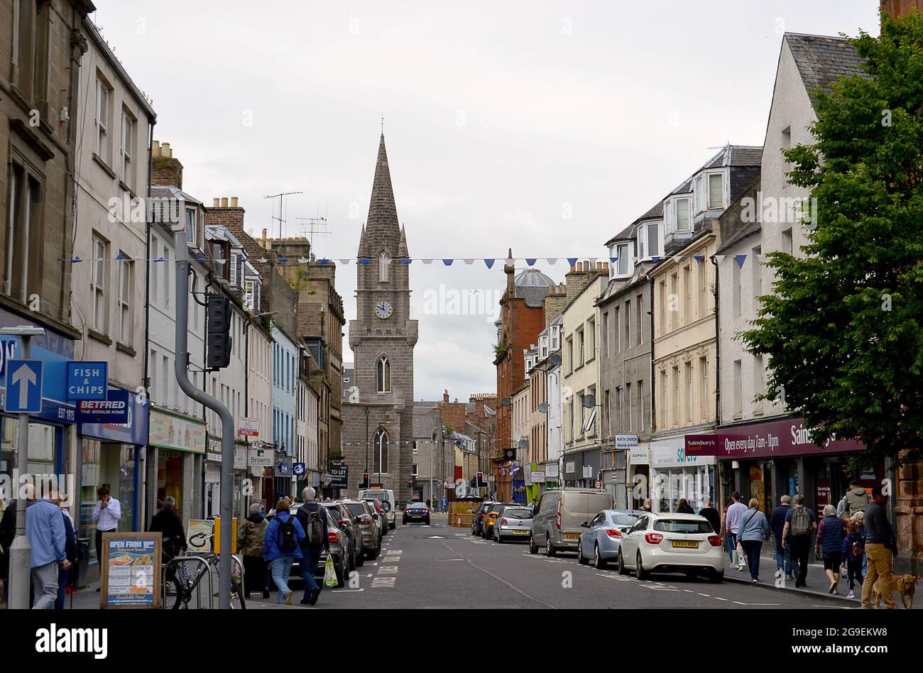 PERTH, SCOTLAND - 25 JUNE 2021: Shoppers fill the city's Old High Street dominated by the steeple of St Paul's Church Stock Photo