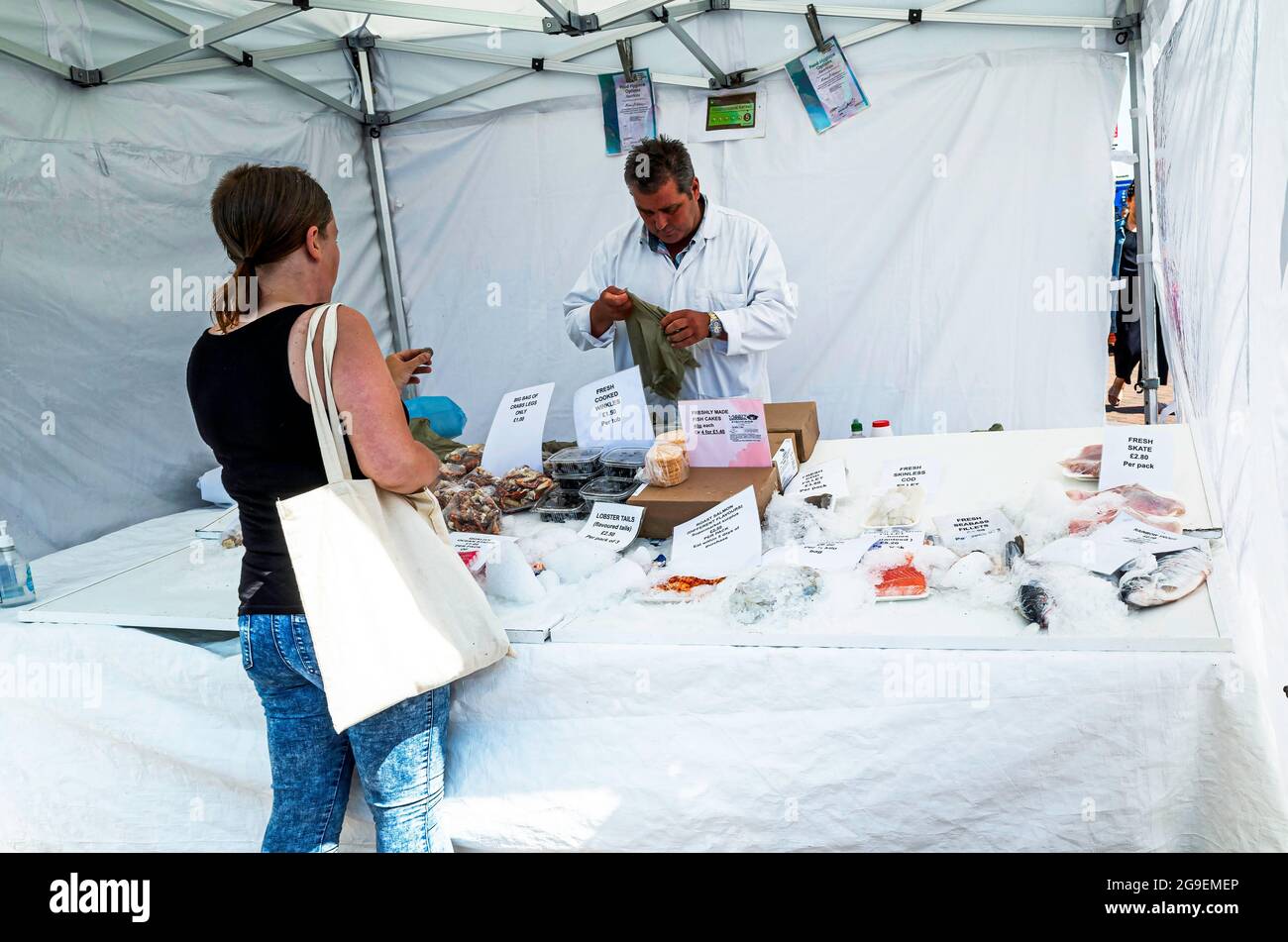 A woman customer  buying from a specialist seafood market stall in North Yorkshire Stock Photo