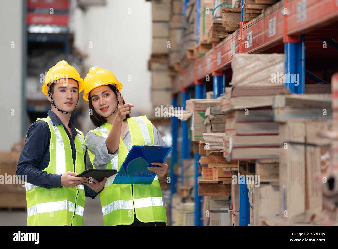 Warehouse worker checking packages on shelf in a large store Stock Photo
