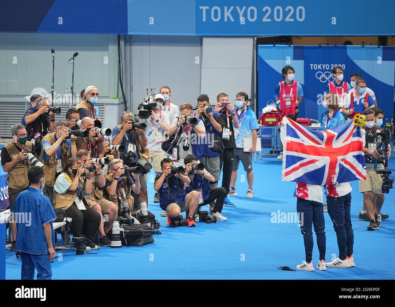 Tokio, Japan. 26th July, 2021. Swimming: Olympics, preliminary competition, water diving - synchronised diving 10m, men at Tokyo Aquatics Centre. First-placed Thomas Daley and Matty Lee of Great Britain celebrate with a British flag after the competition. Credit: Michael Kappeler/dpa/Alamy Live News Stock Photo