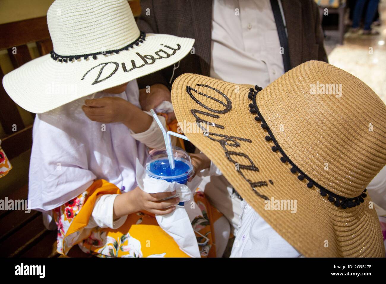 Two young fashionistas wearing Dubai hats on their holiday in the UAE