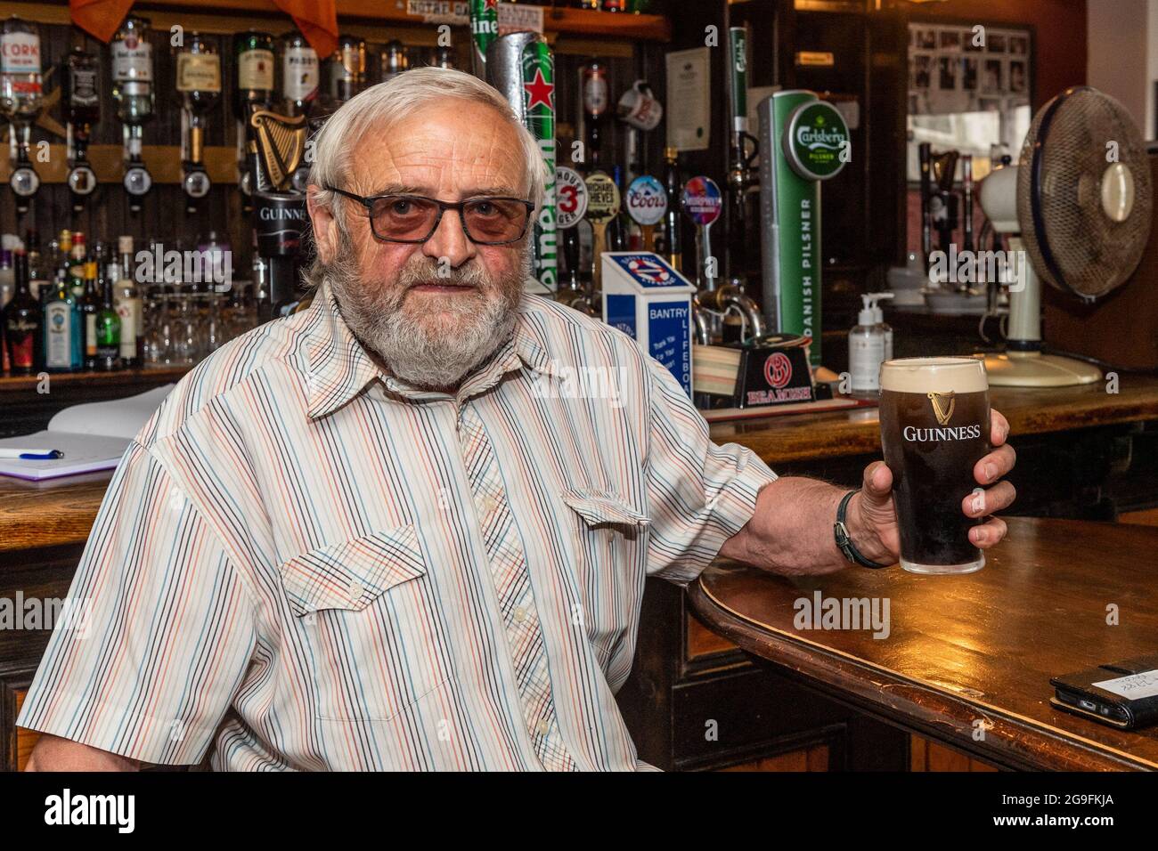 Bantry, West Cork, Ireland. 26th July, 2021. Today the so called 'wet pubs' reopened for the first time since the start of the pandemic. First customer through the door of the Boston Bar was regular Eugene Hickey from Bantry. Credit: AG News/Alamy Live News Stock Photo