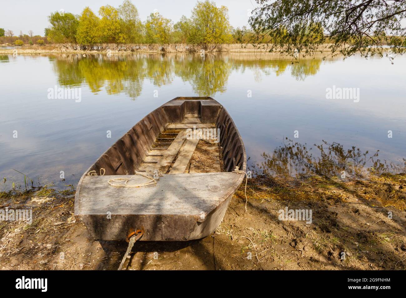 Old wooden row boat anchored on the shore Stock Photo - Alamy