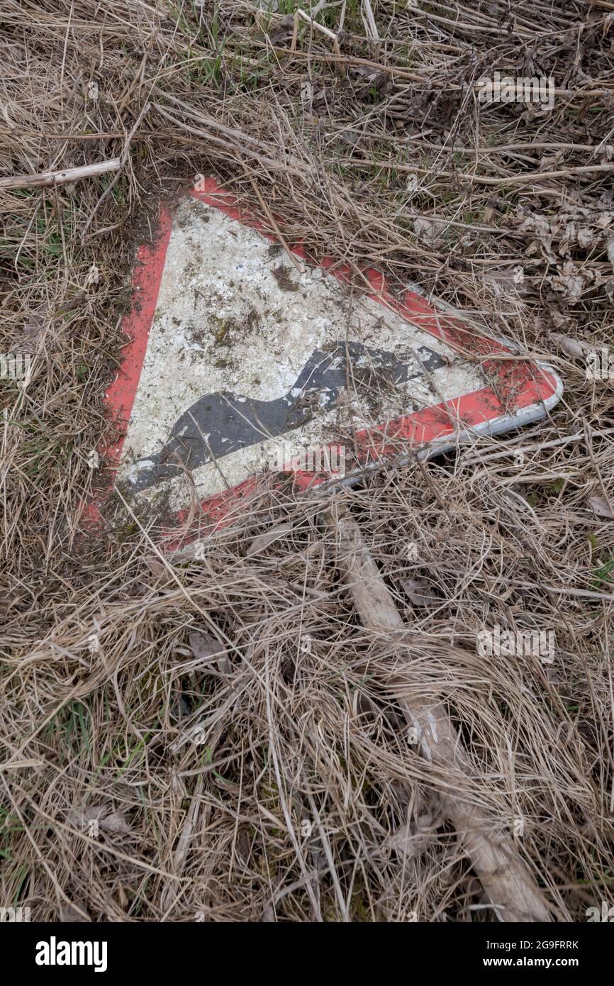 Road sign rough road lying on a ground. Triangular road sign. Stock Photo