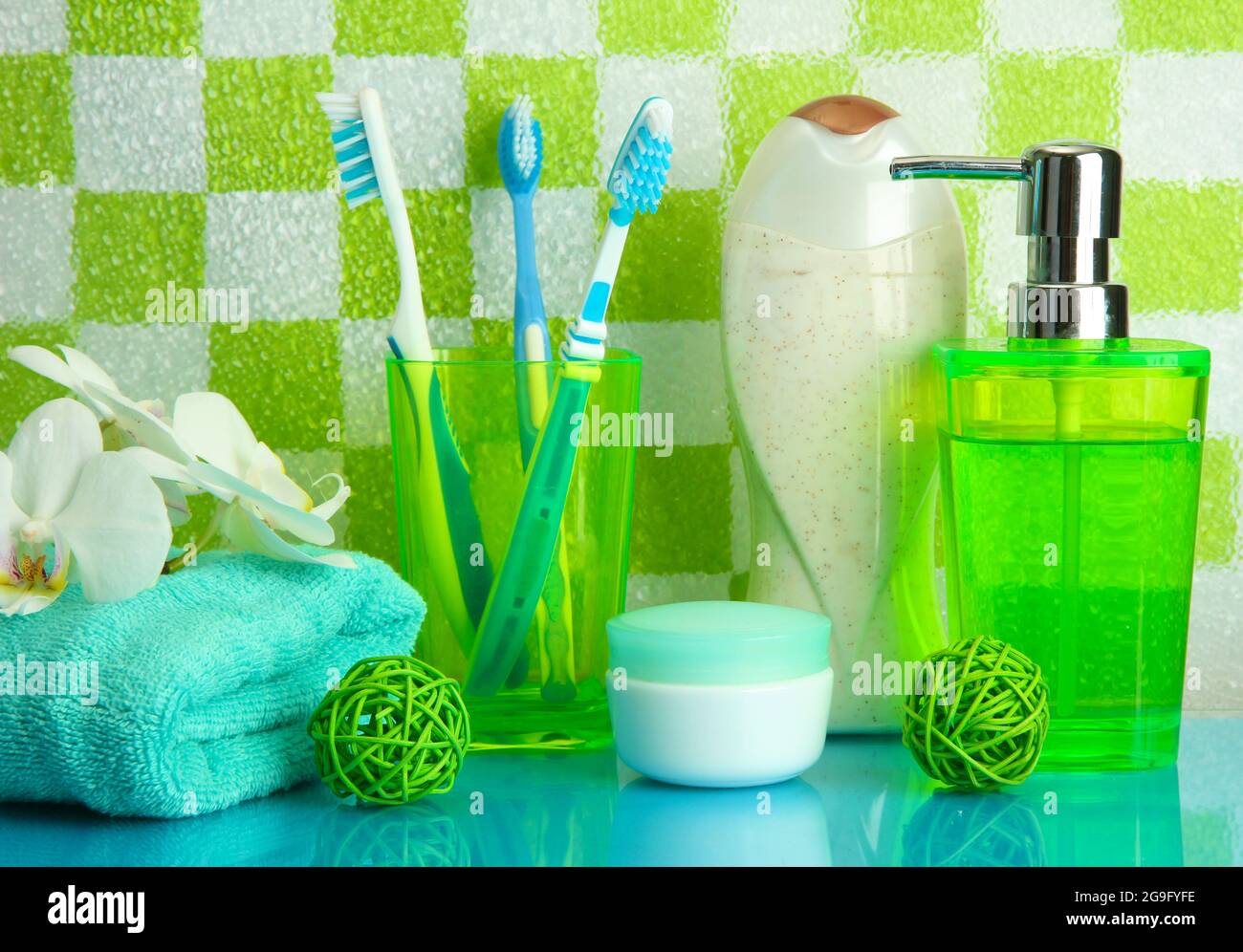 Bath accessories on shelf in bathroom on green tile wall background ...