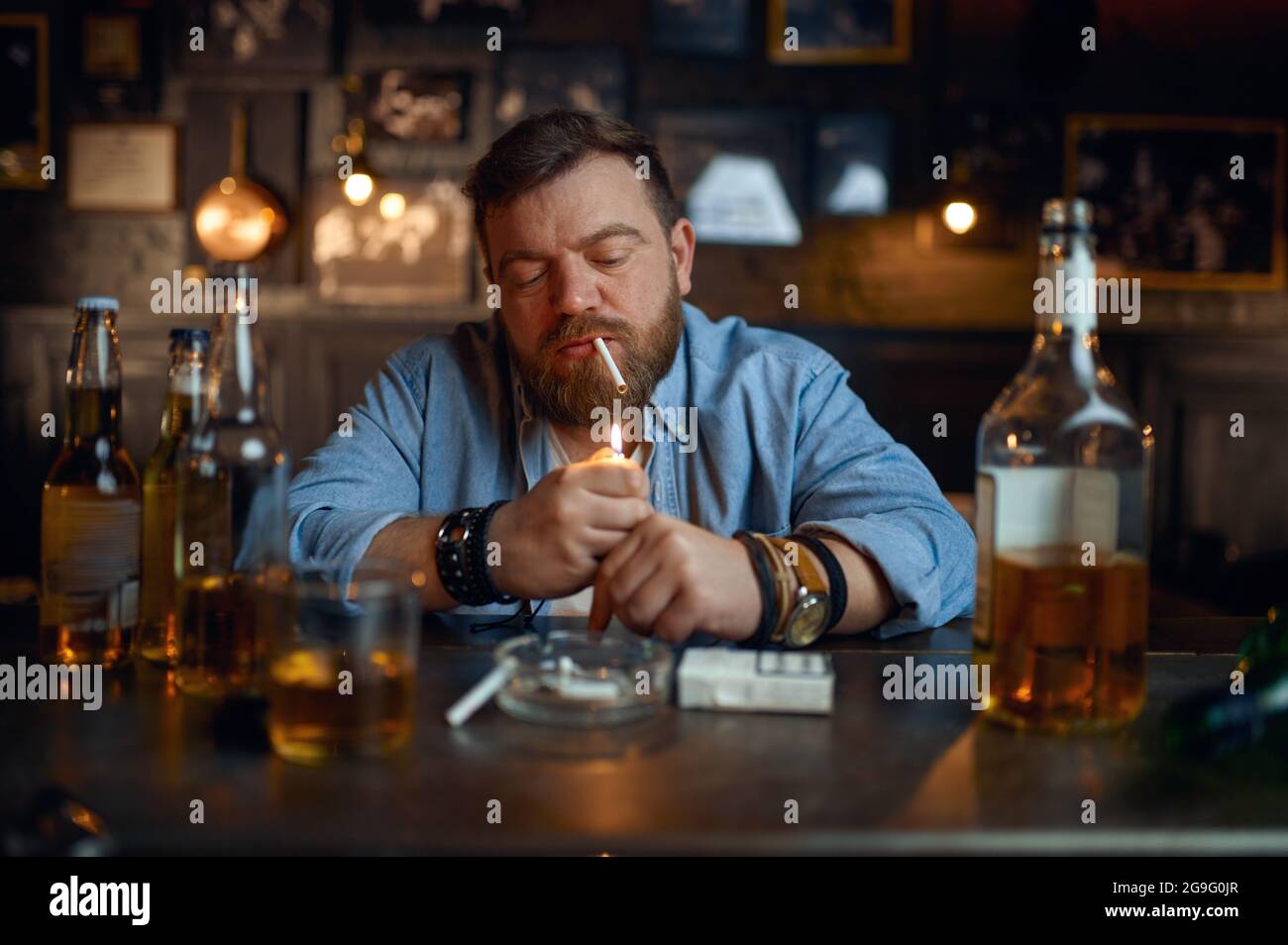 Drunk man smokes a cigarette at the counter in bar Stock Photo - Alamy