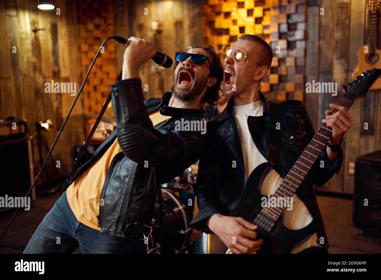 Two musicians at microphone, rock band Stock Photo Alamy