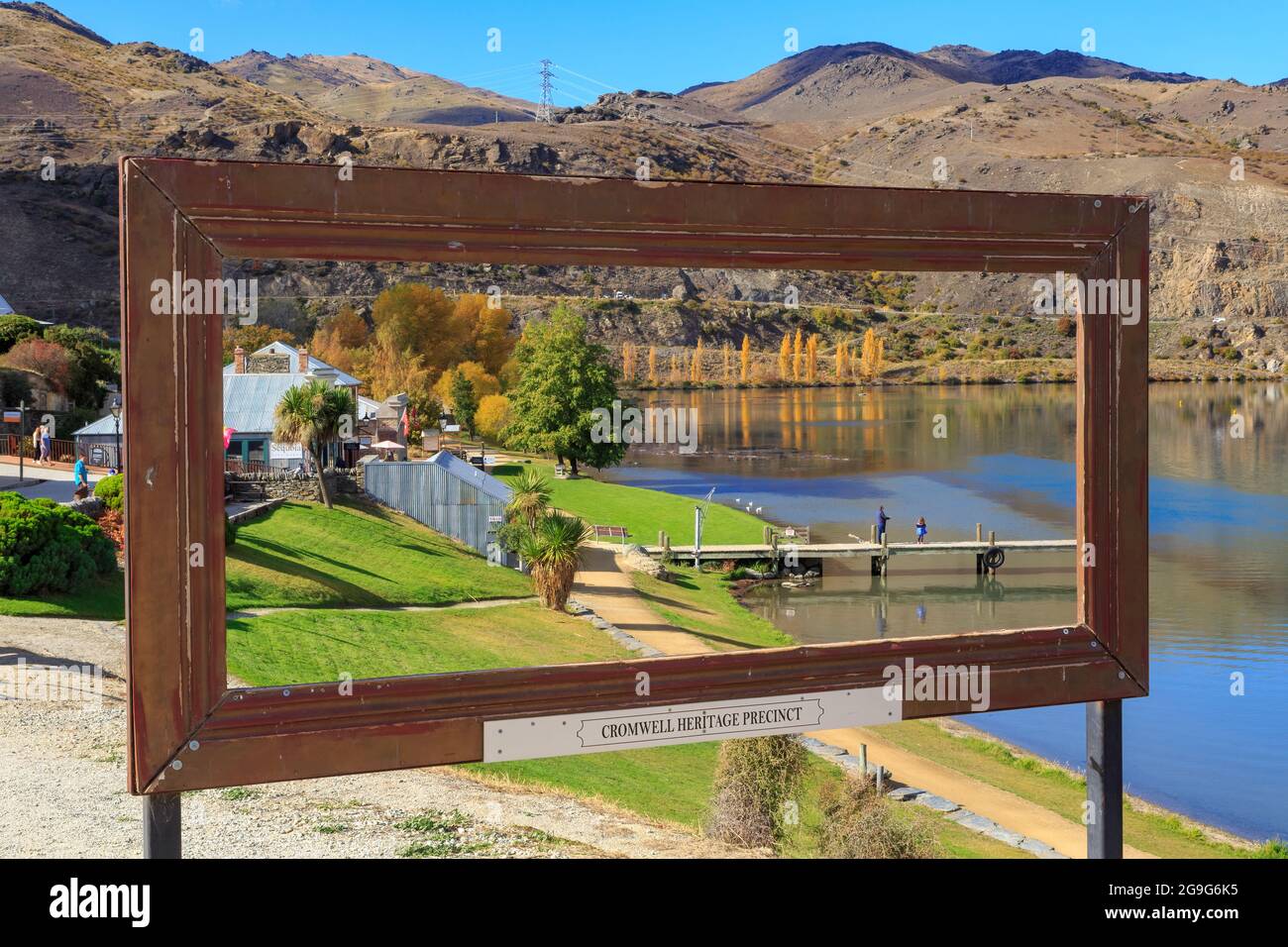Cromwell, New Zealand. The Cromwell Heritage Precinct, a collection of gold rush era buildings on the edge of Lake Dunstan, seen through a frame Stock Photo