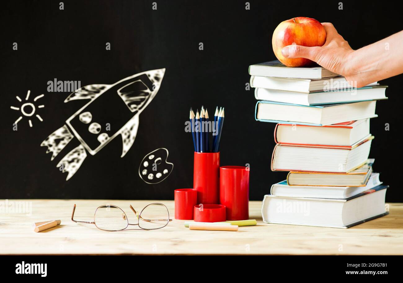 back to school concept pile of books against chalkboard Stock Photo - Alamy