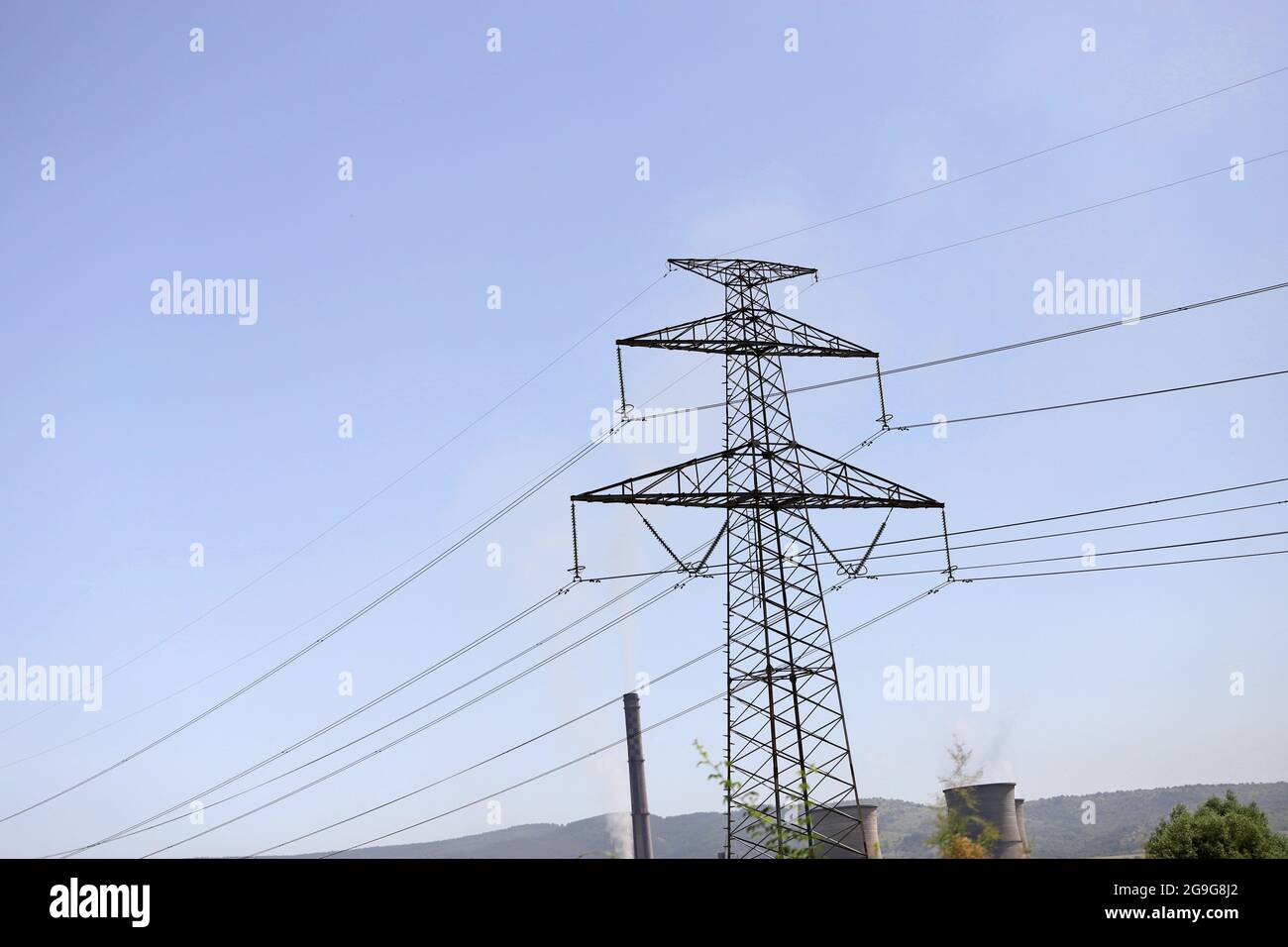 Electricity pylon overhead power line transmission tower with smoke from TPP (thermal plant) Stock Photo