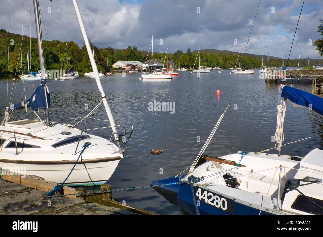 A lakeside scene with boats on their moorings in the Lake District, Cumbria, England, UK Stock Photo