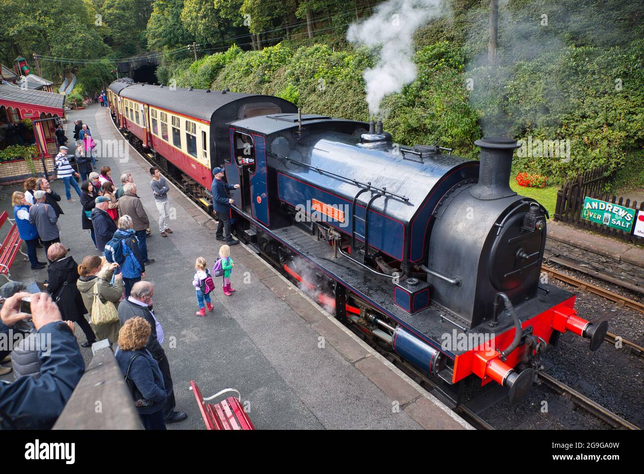 People looking at an old steam train at a station in the Lake District, Cumbria, England, UK Stock Photo