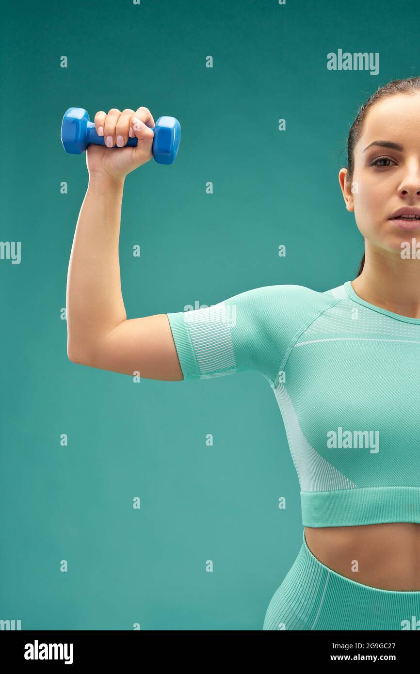 Sporty young woman holding small fitness dumbbell Stock Photo
