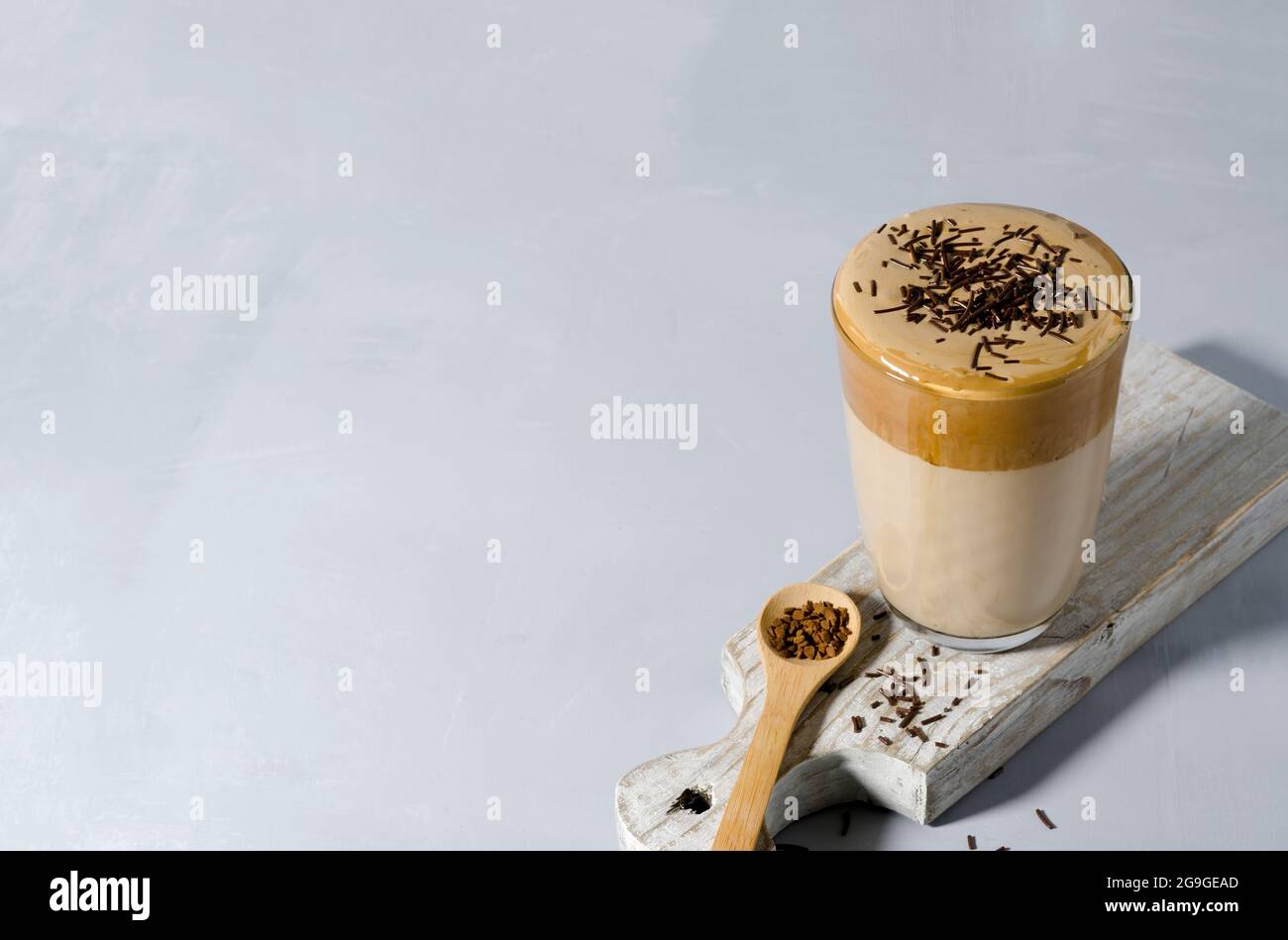 Cold coffee in a high glass on a wooden board with copying text Stock Photo