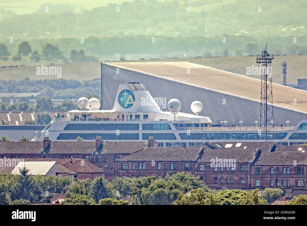 Glasgow, Scotland, UK, 26th  July, 2021.Azamara  quest cruise ship leaves the  clyde  after covid  as the tourist industry resumes and it towers over the tenements on the bank.  Credit: Gerard Ferry/Alamy Live News Stock Photo