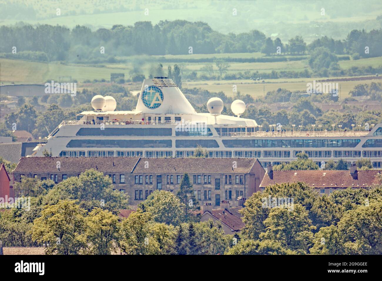 Glasgow, Scotland, UK, 26th  July, 2021.Azamara  quest cruise ship leaves the  clyde  after covid  as the tourist industry resumes and it towers over the tenements on the bank.  Credit: Gerard Ferry/Alamy Live News Stock Photo
