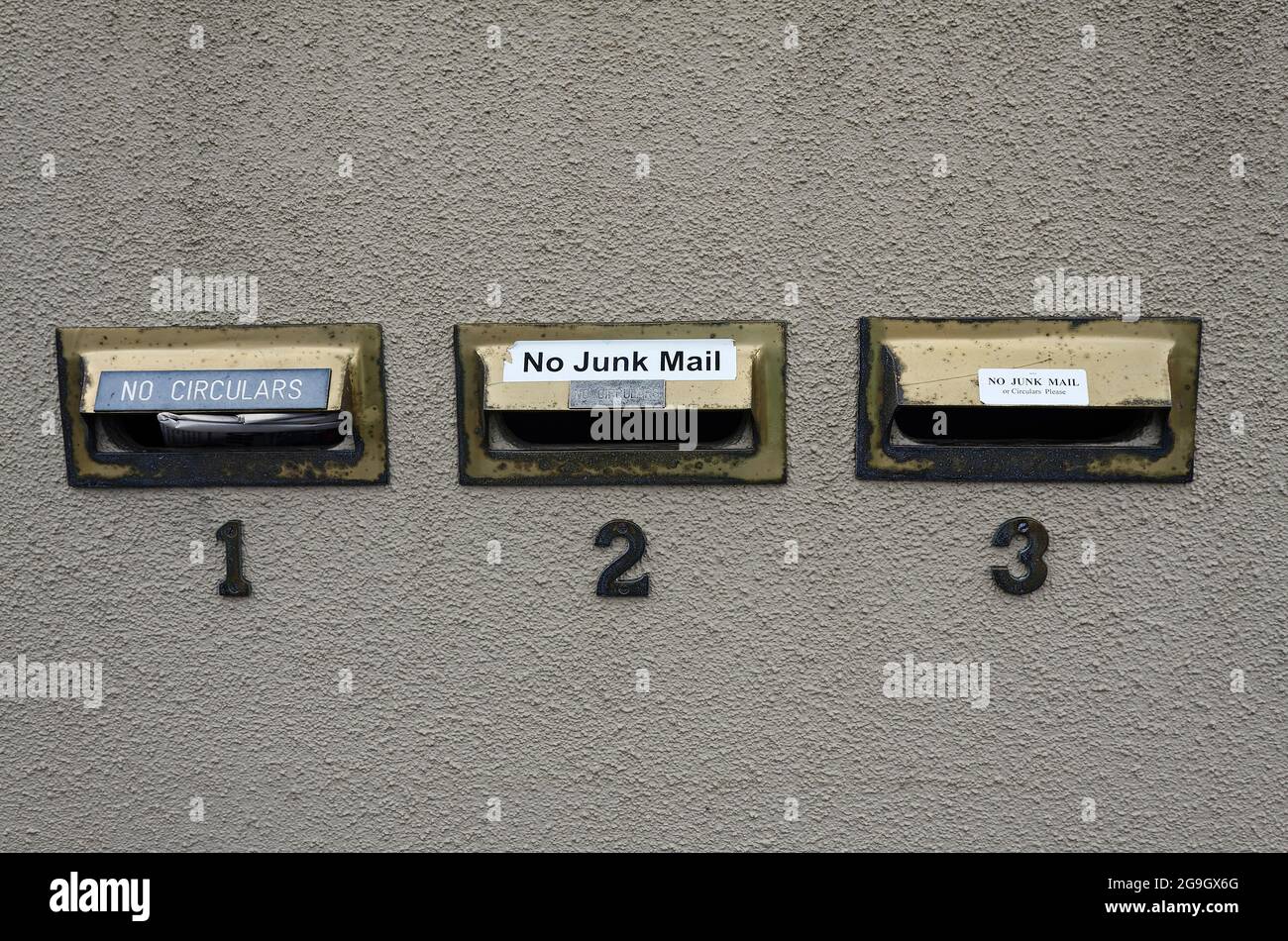 No Circulars, No Junk Mail signs, 3 mail box slots, rough cement wall, text, words, Auckland, New Zealand Stock Photo