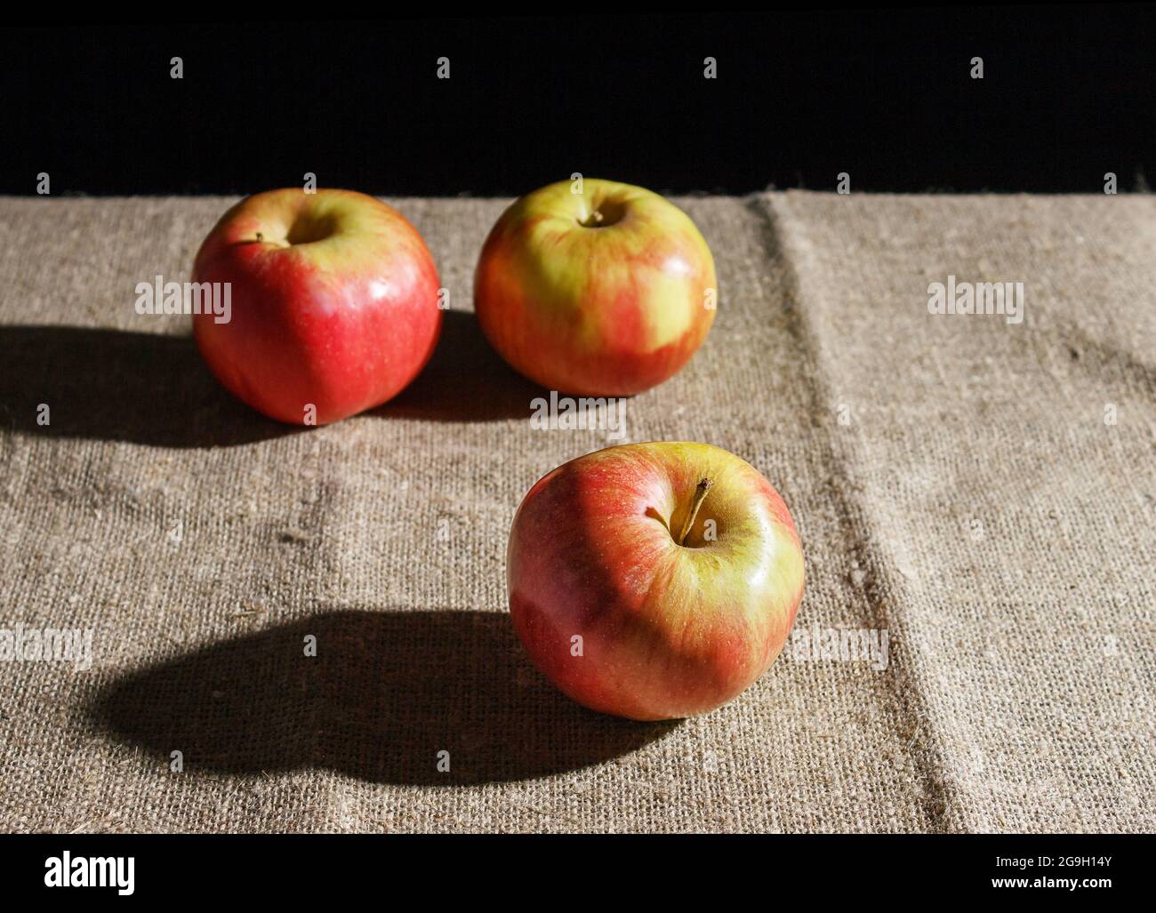 three red apples on the table. closeup on black background Stock Photo