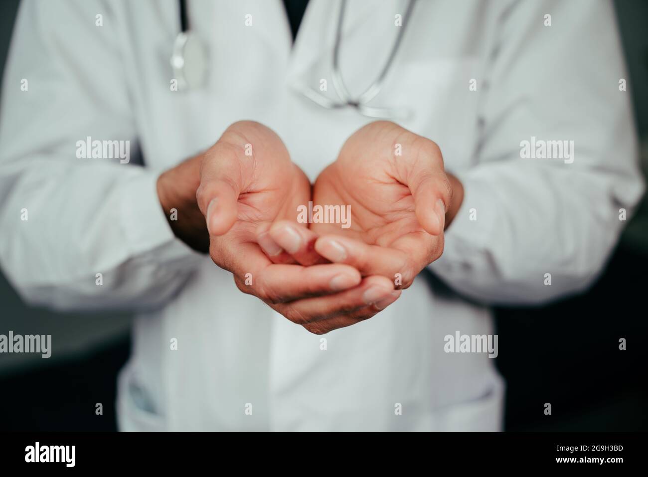 Caucasian male doctor standing in office with hands open Stock Photo