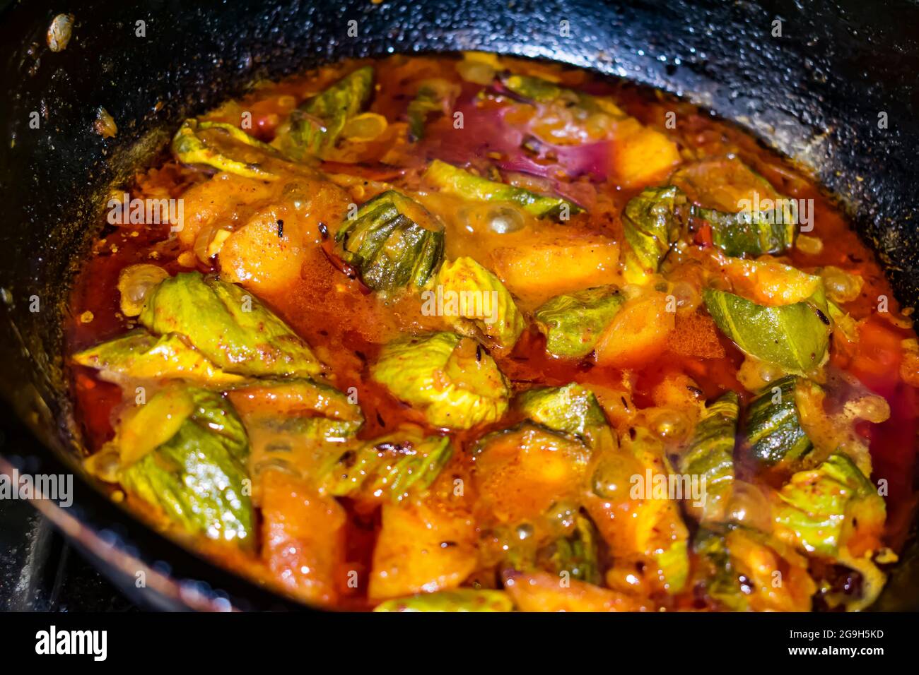 Indian red spicy curry made with potato & Coccinia in home. Stock Photo