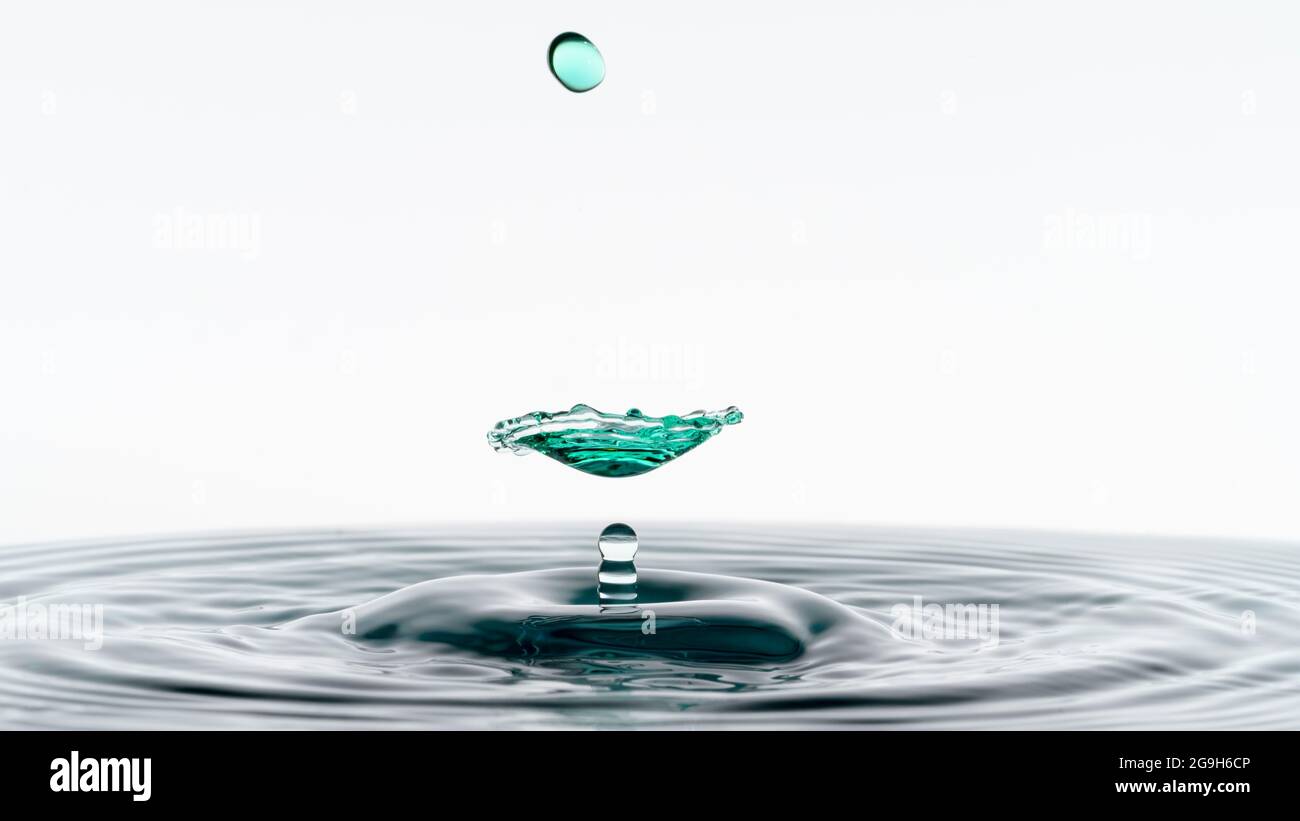 Close-up photograph of two water droplets colliding making an unusual ...