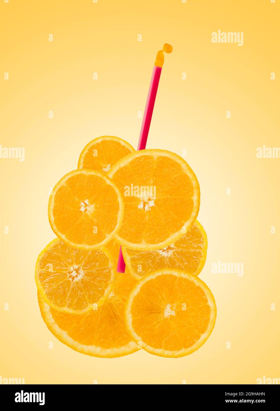 Orange slices in glass shape with straw on orange background Stock Photo