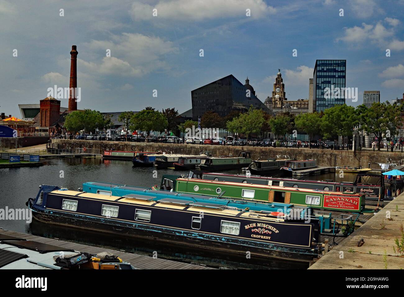 Summer in the city, canal boats moored in Salthouse dock Liverpool overlooked by the pier head buildings, including the Liver buildings Stock Photo