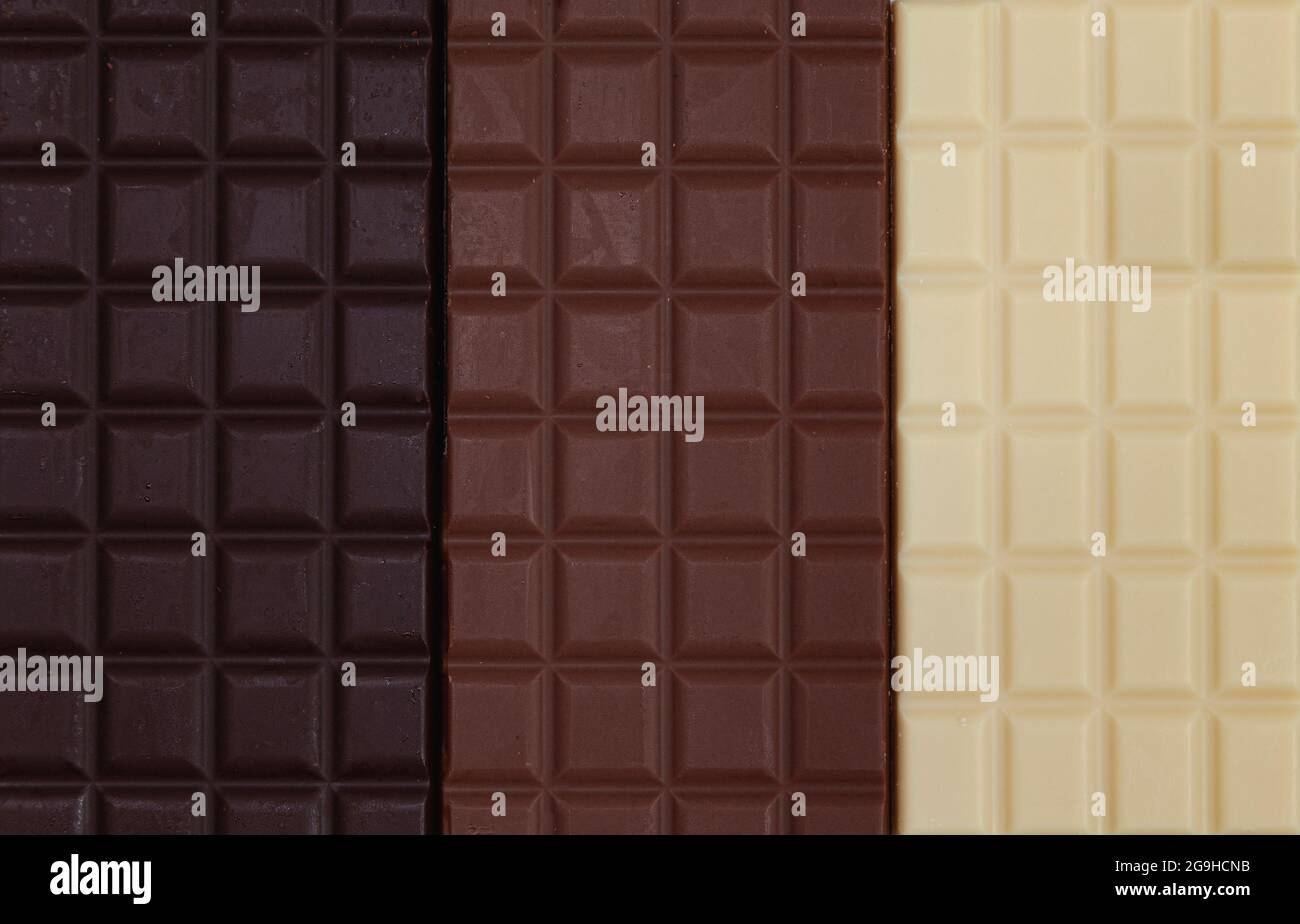 Close-up of three chocolate bars together, one is dark chocolate, one is milk chocolate and one is white chocolate. Stock Photo