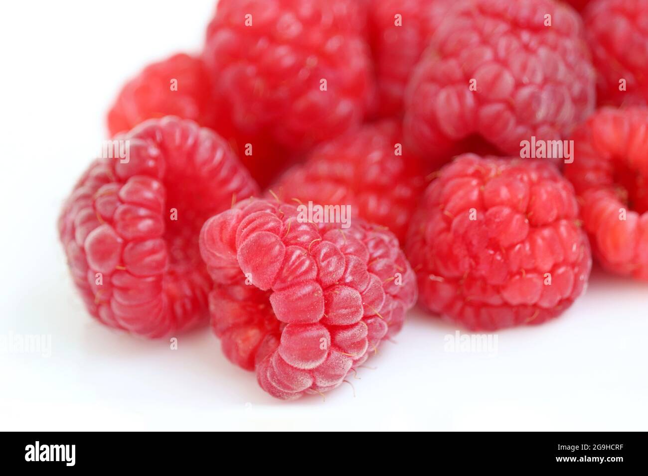 Red raspberry on white background. Pile of ripe berries close up, summer crop Stock Photo